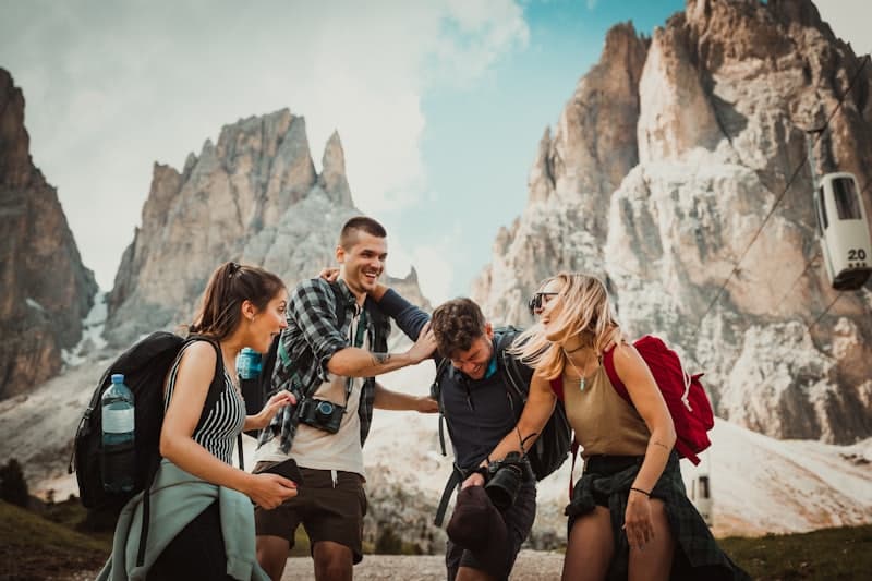 Friends laughing together beneath jagged peaks